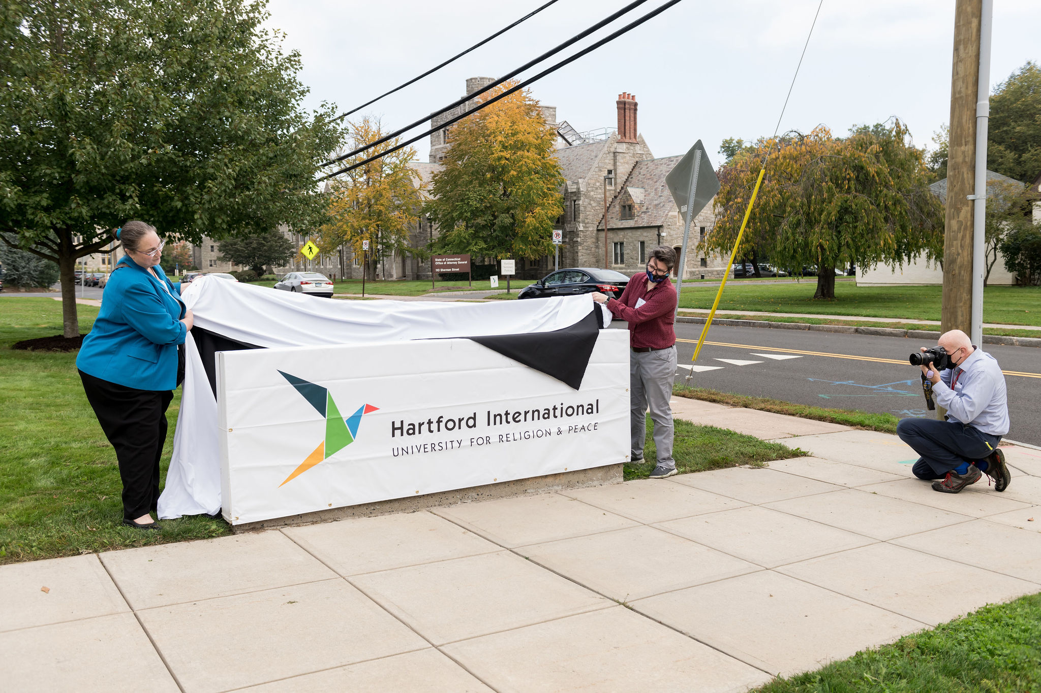 Two people unveiling the new sign