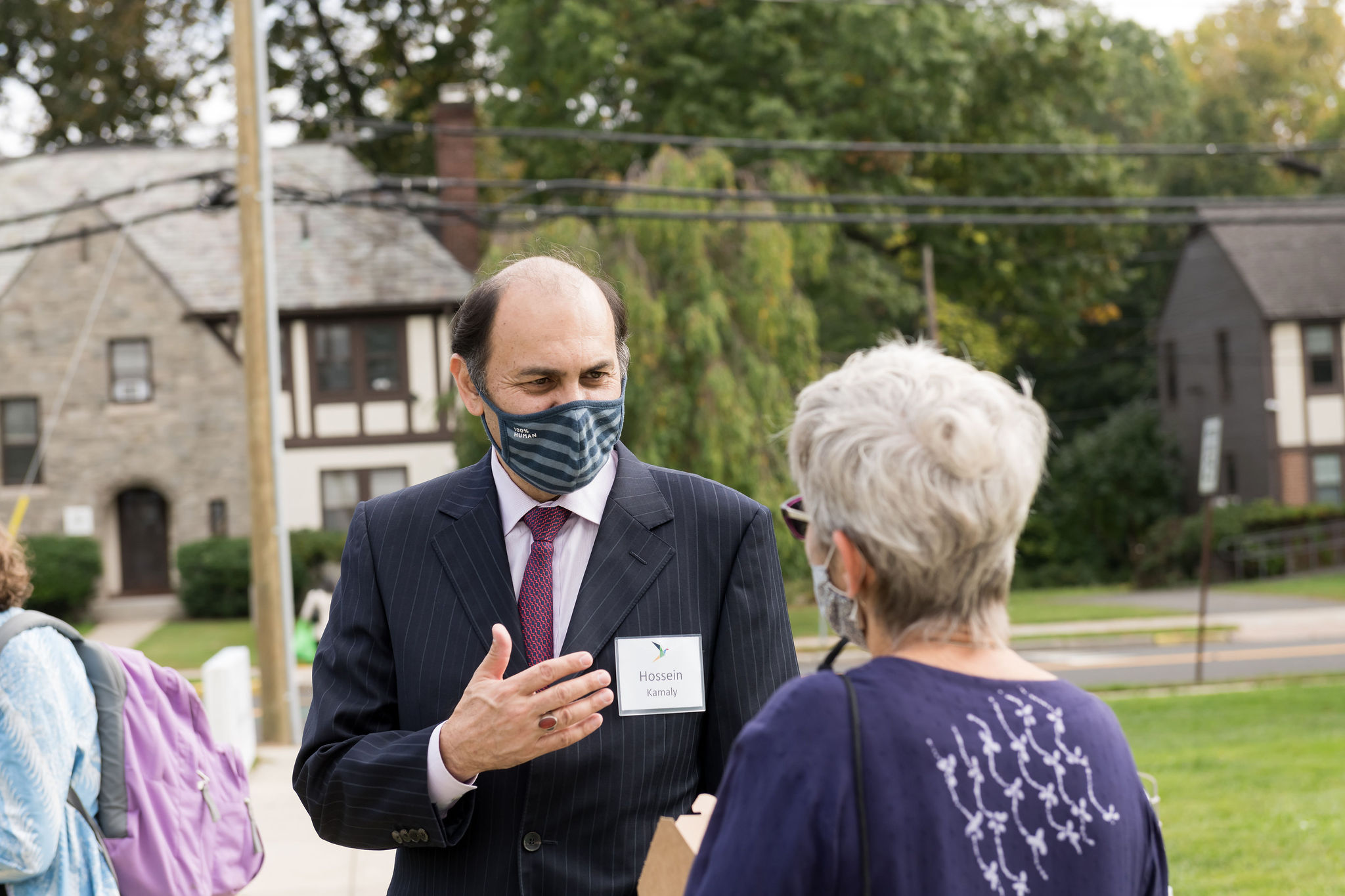 Professor Hossein Kamaly speaking to a woman with short gray hair