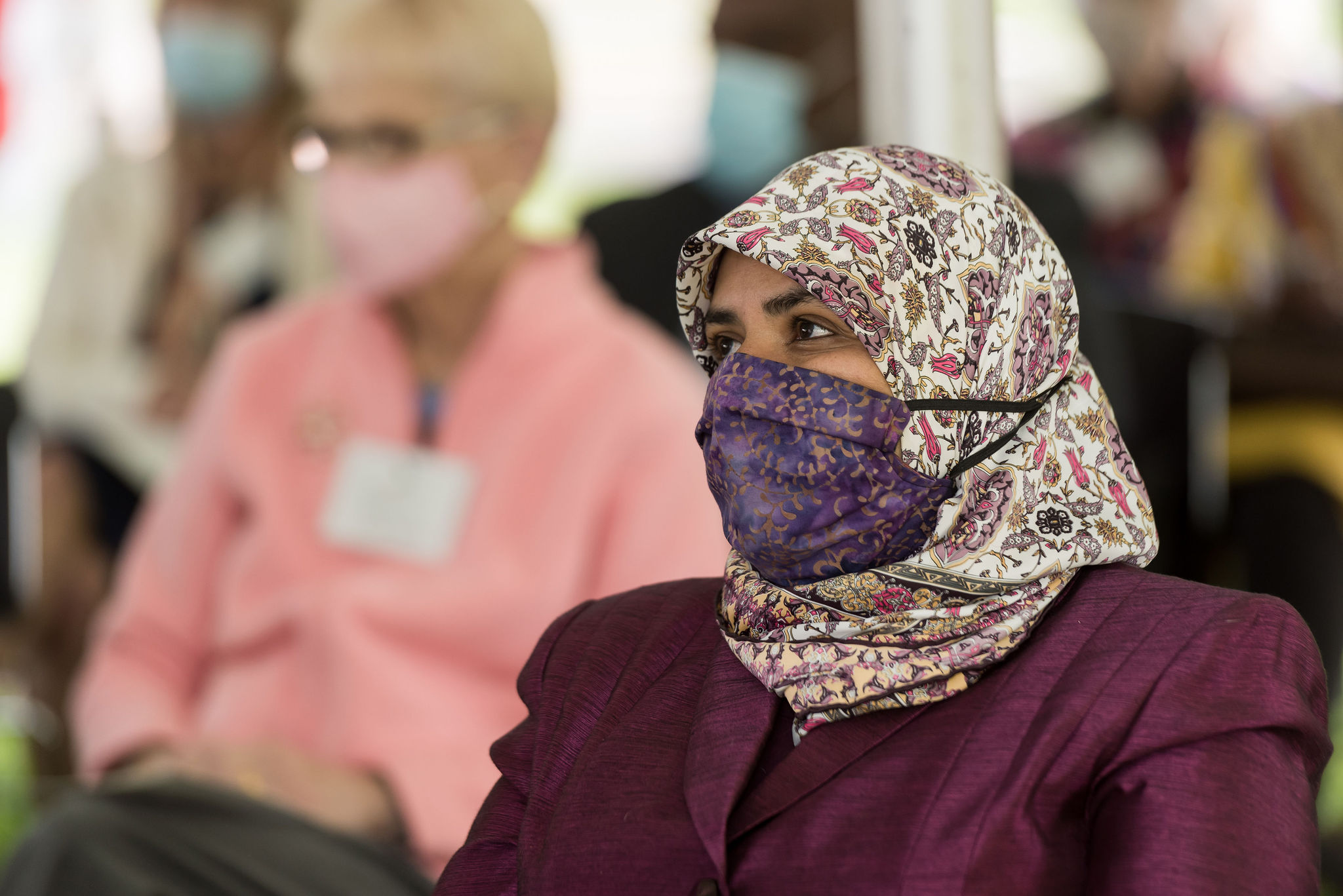 Aida Mansoor listening, wearing mask