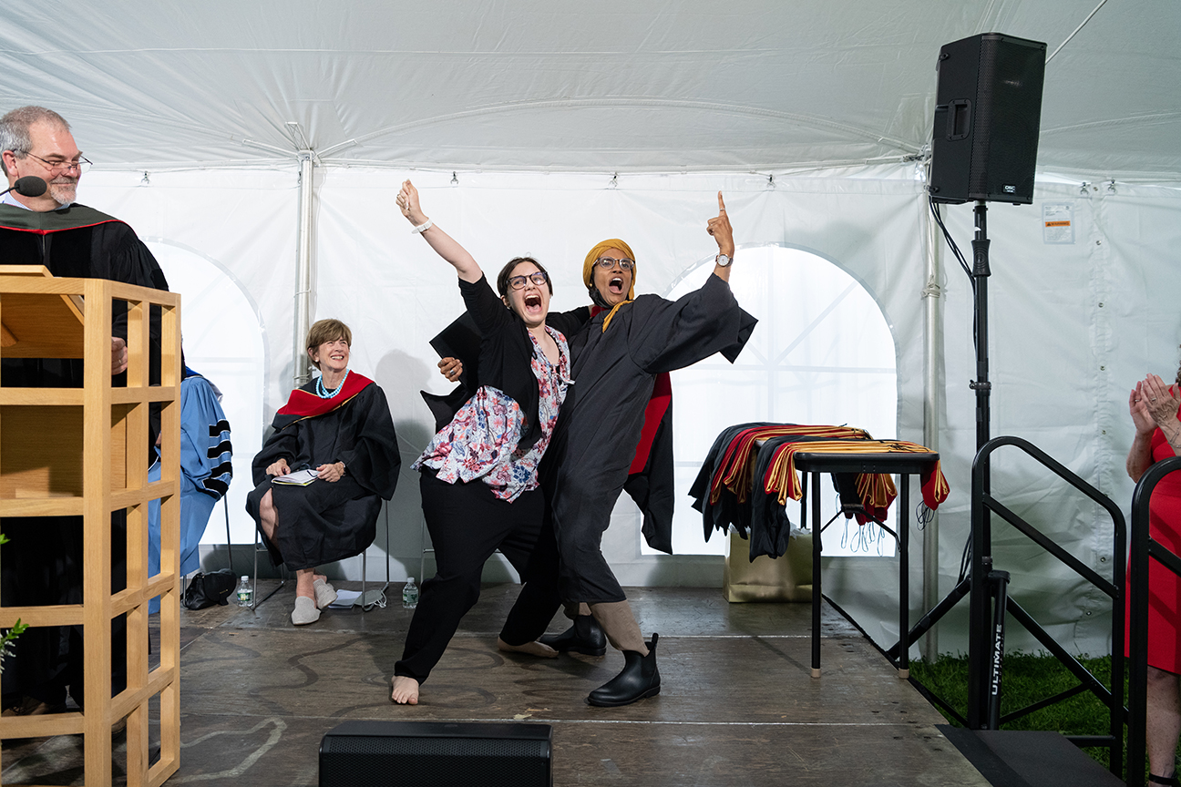 Two graduates celebrating effusively