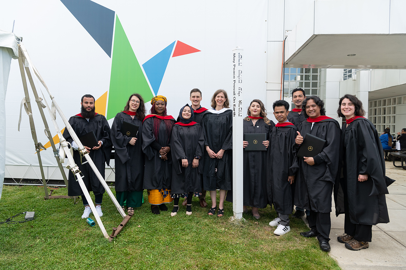 Graduates in front of dove sign