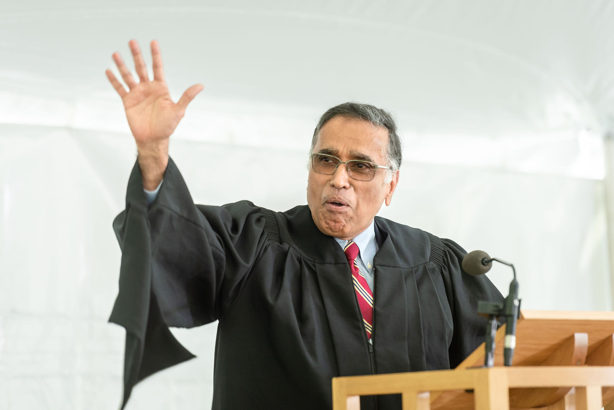 A speaker gesturing from a podium