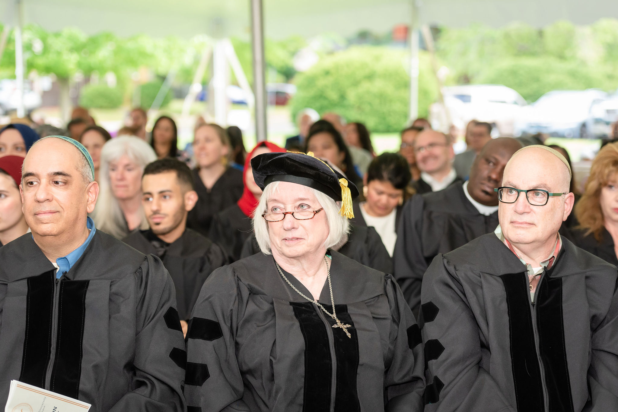 A crowd of seated graduates listening