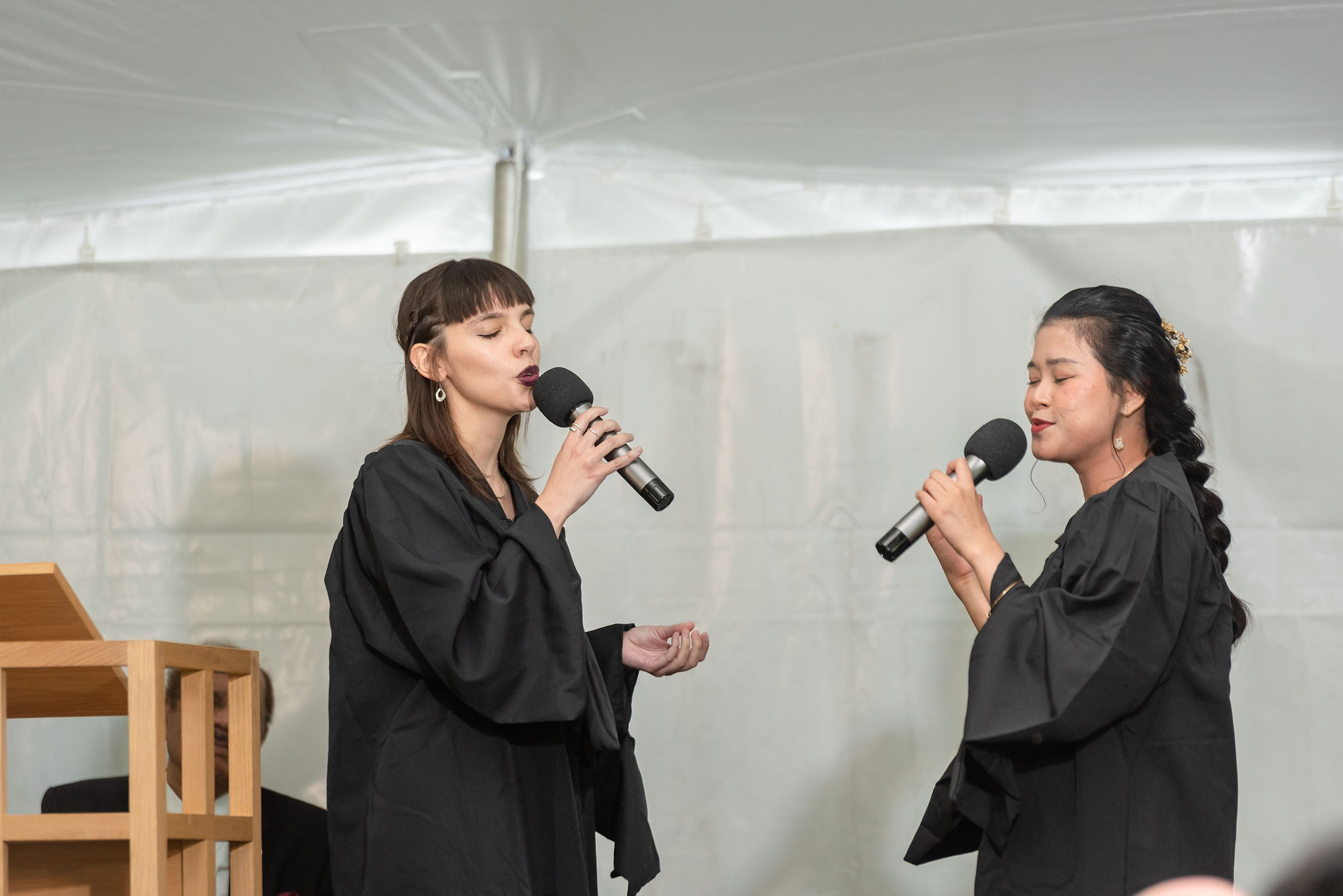 Two women singing into microphones