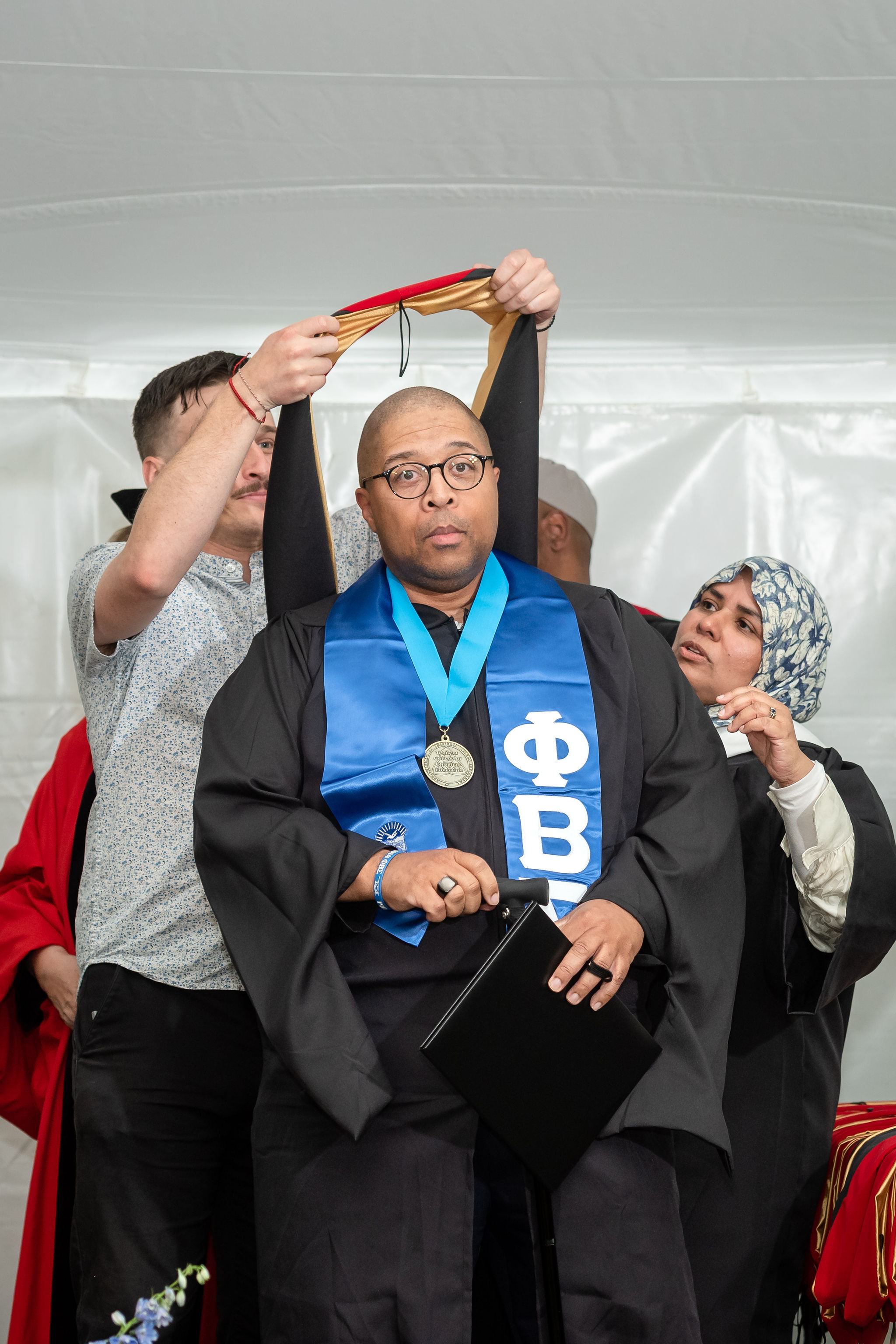 Man receiving graduation hood