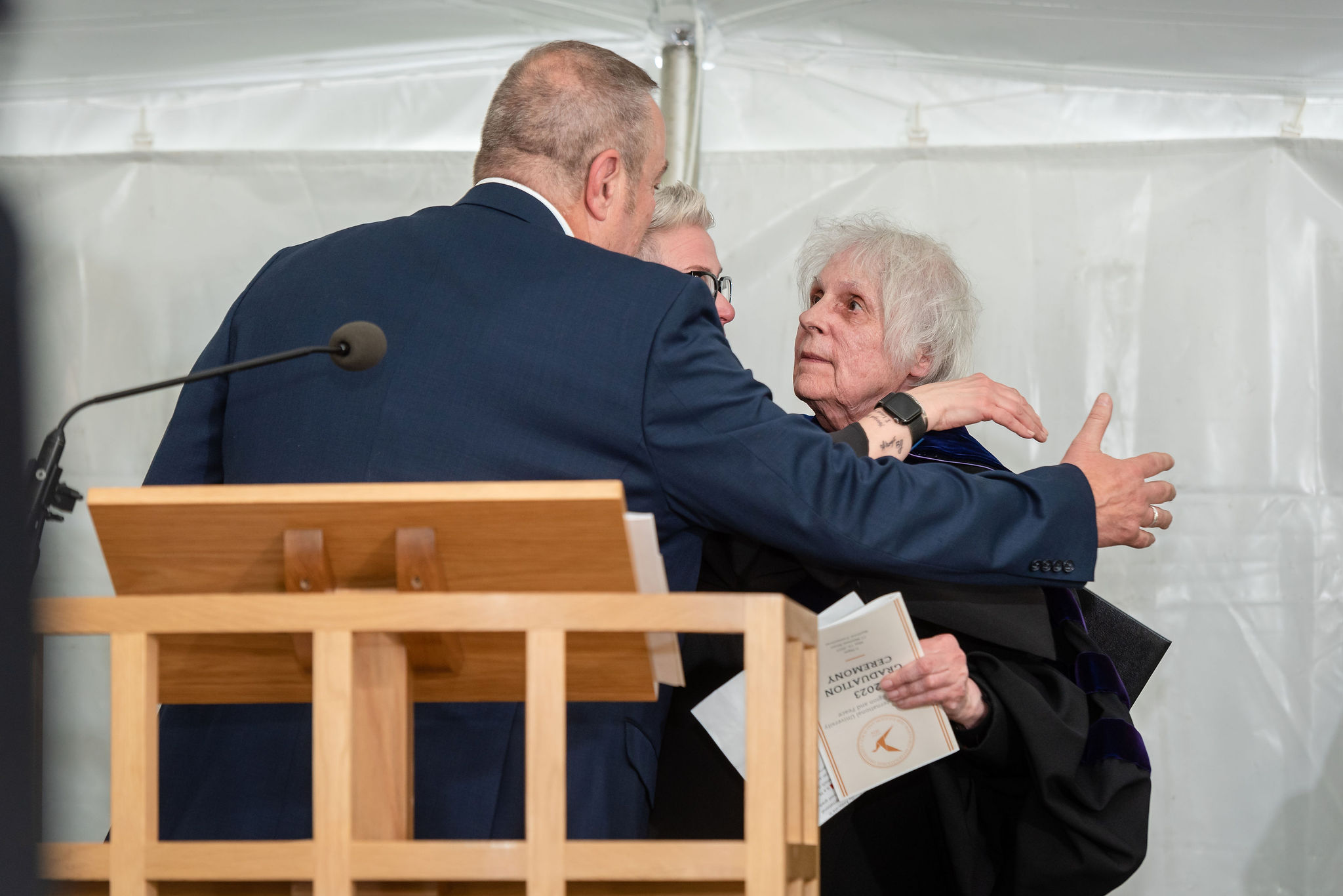 Woman giving hug to man and woman