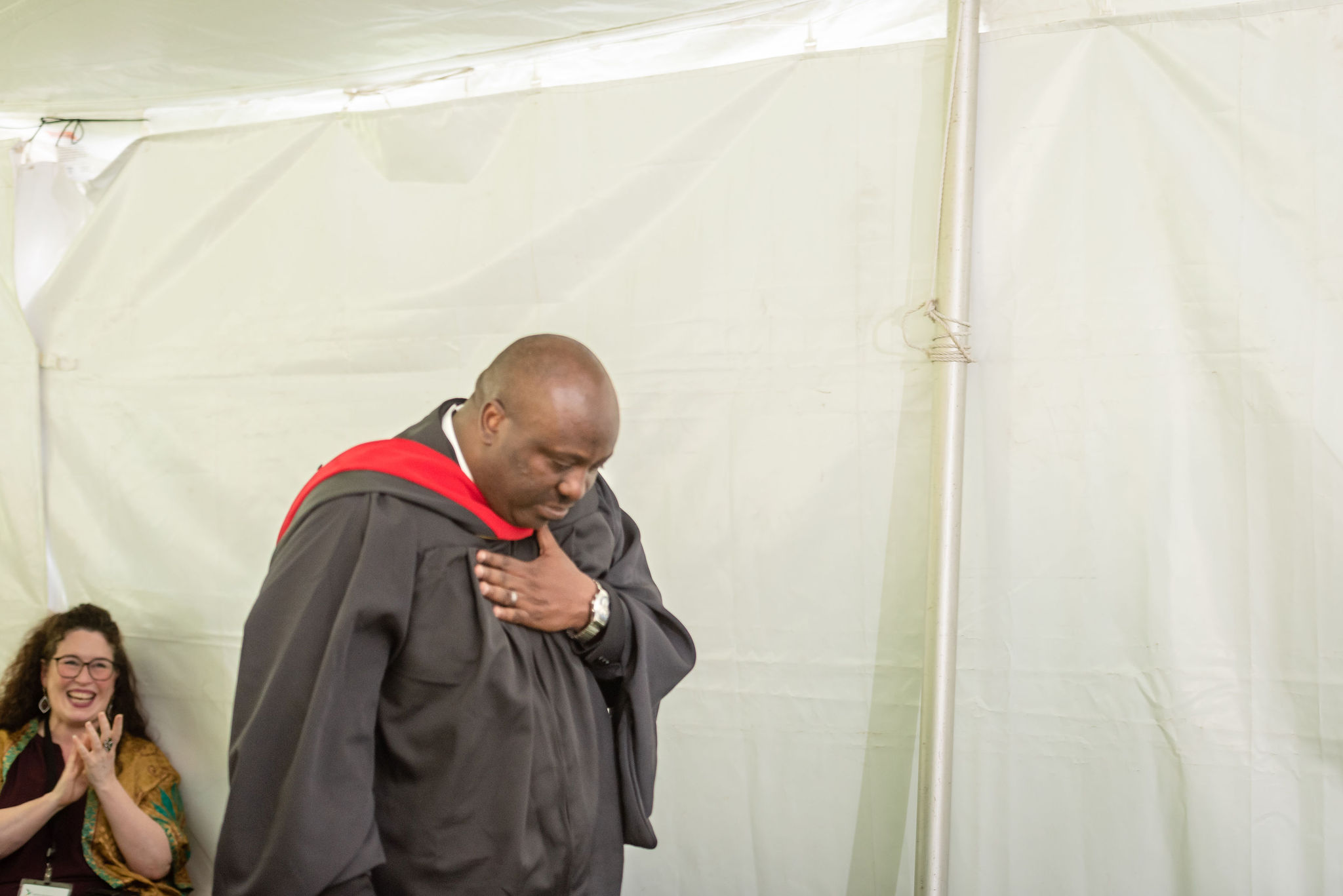 Man in graduation robe with hand over heart