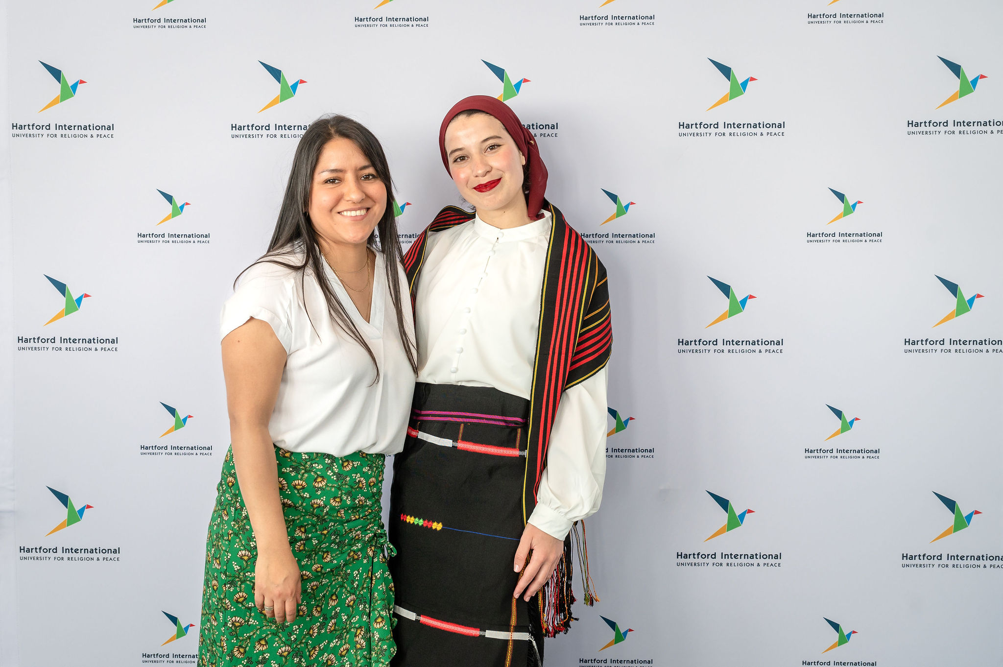 Two women in front of banner