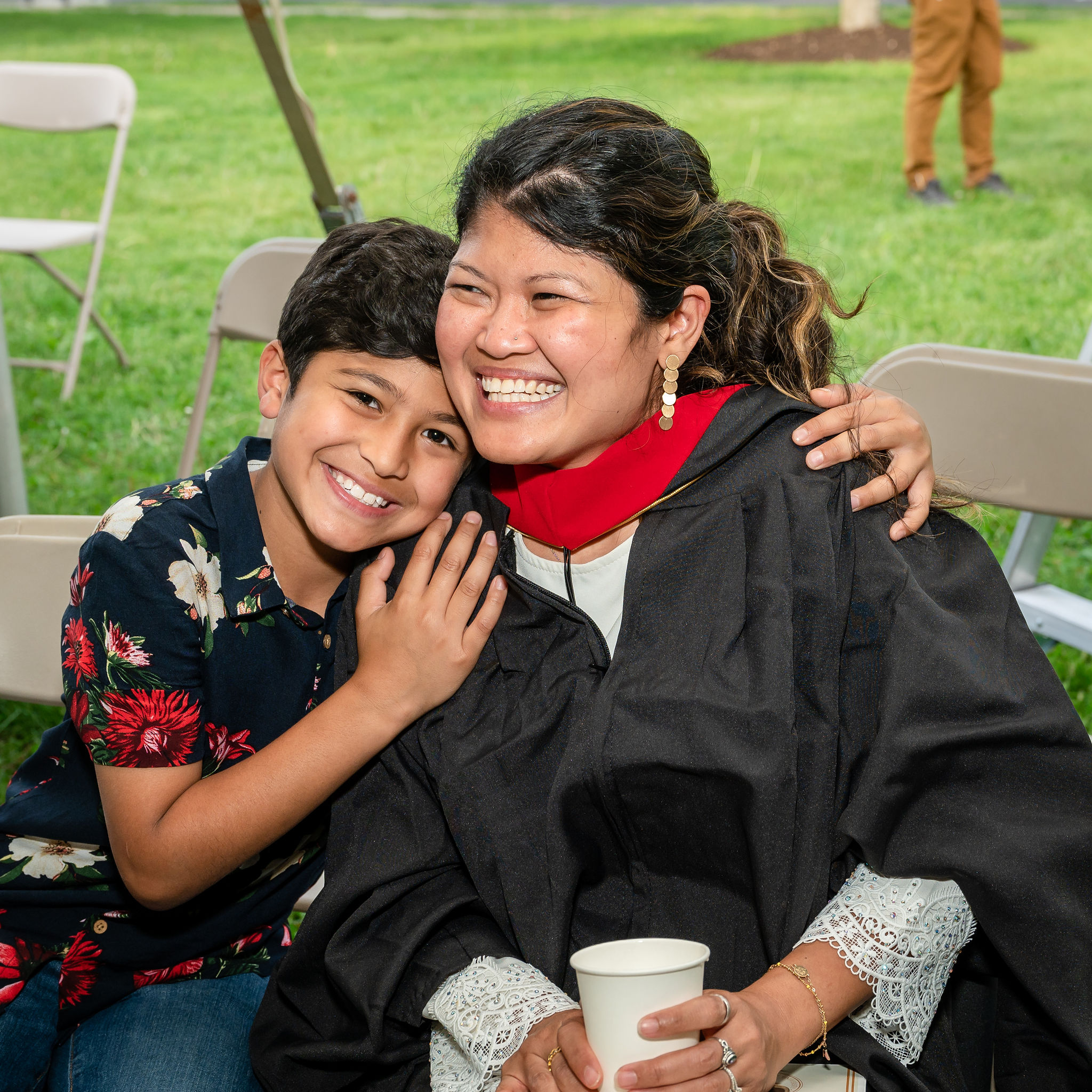 Woman graduate smiling with young boy