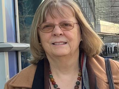 Headshot of woman with glasses and a necklace